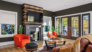 Una sala de estar moderna con chimenea, un ventanal con persianas y un sofá de cuero.