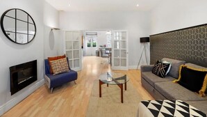 Una sala de estar moderna con chimenea, un sofá, una mesa de centro y un televisor.
