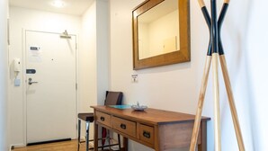 A room with a wooden desk, a mirror, and a door with a sign. - Stunning Views Central Apt (Auckland)