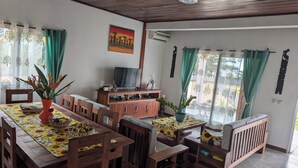 Un comedor con muebles de madera, un televisor y un cuadro en la pared.