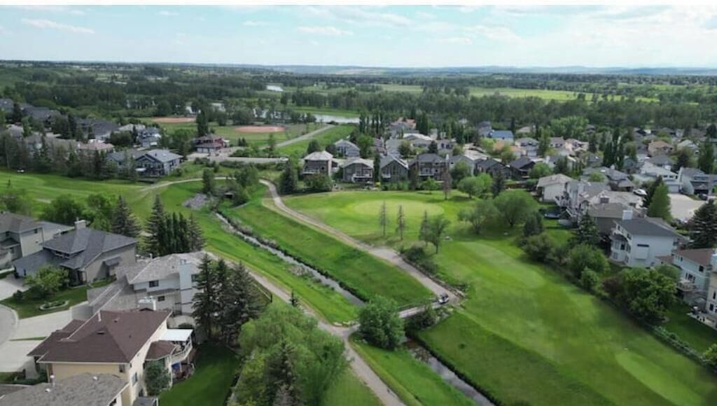 Un quartier résidentiel avec des maisons, de vastes pelouses verdoyantes et un terrain de golf.