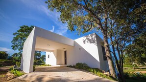 Ein modernes Haus mit einzigartigem architektonischen Design, mit einer großen, weit überhängenden Struktur und einem gepflegten Garten.