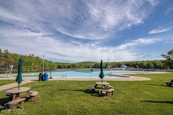 Ein Swimmingpool mit Picknickplatz und Seeblick.