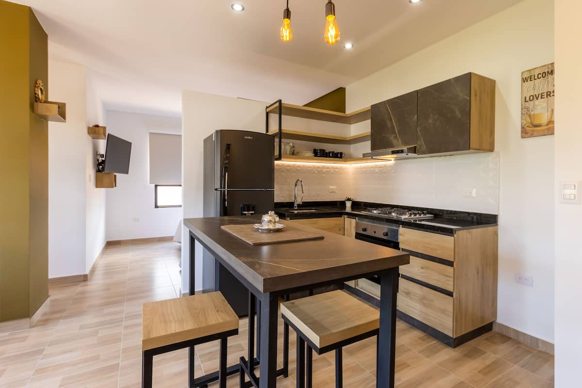 Uma cozinha moderna com ilha central, eletrodomésticos embutidos e armários de madeira.