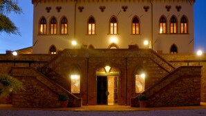 Un bâtiment qui ressemble à un château, avec un escalier en pierre menant à l’entrée principale.
