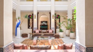 A spacious lobby with a central seating area, large windows, and decorative plants.