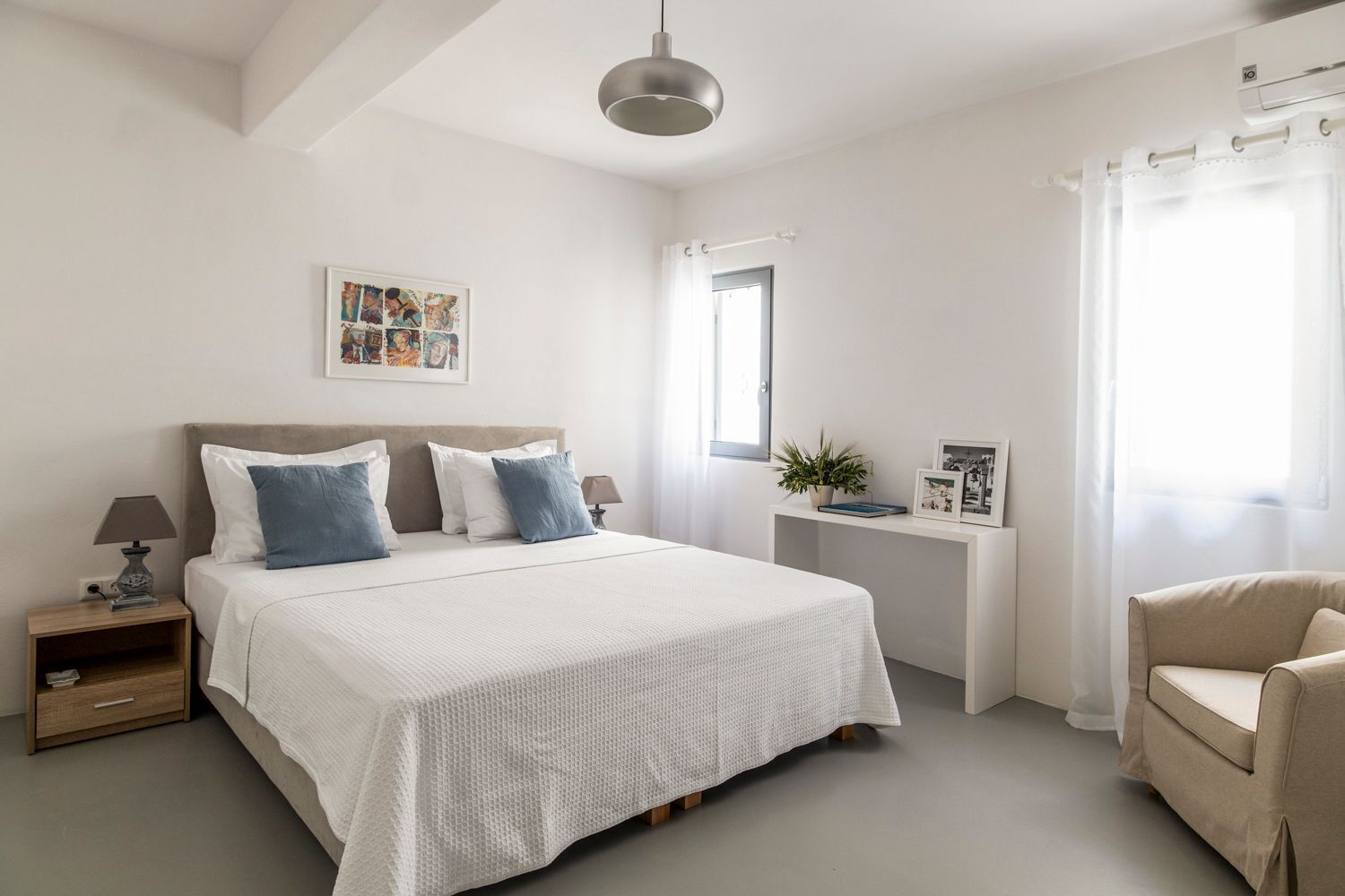 A bedroom with a bed, bedside tables, a chair, a window with curtains, and a ceiling light.