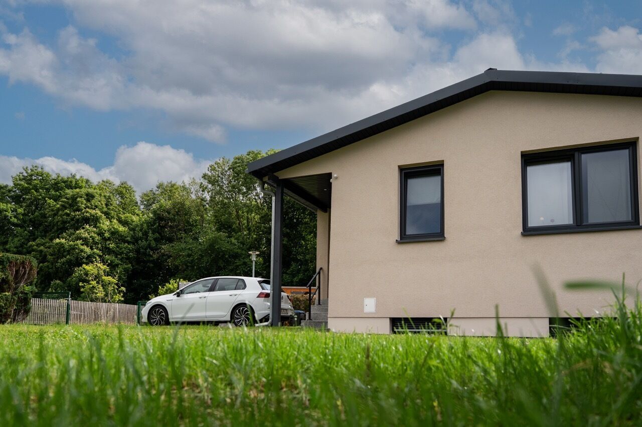 A modern building with a flat roof and a covered entrance.