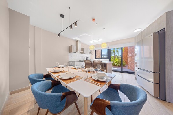 Una cocina moderna con comedor dispuesto para seis.