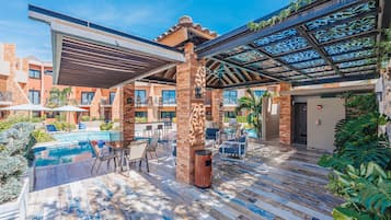 Ein Poolbereich mit Außenmöbeln, einer überdachten Terrasse und Blick auf den Pool.