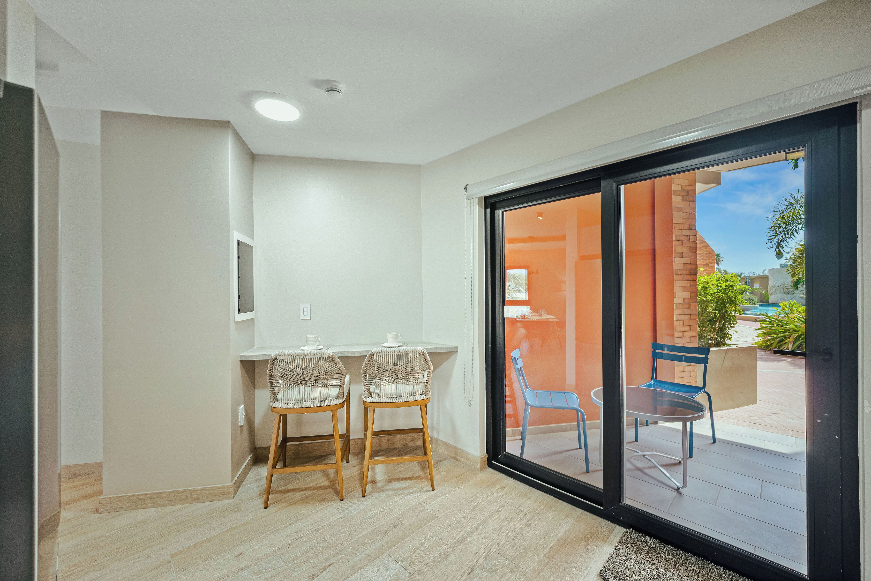 Quarto com porta de vidro deslizante que dá para um pátio externo.