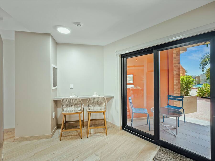Quarto com porta de vidro deslizante que dá para um pátio externo.