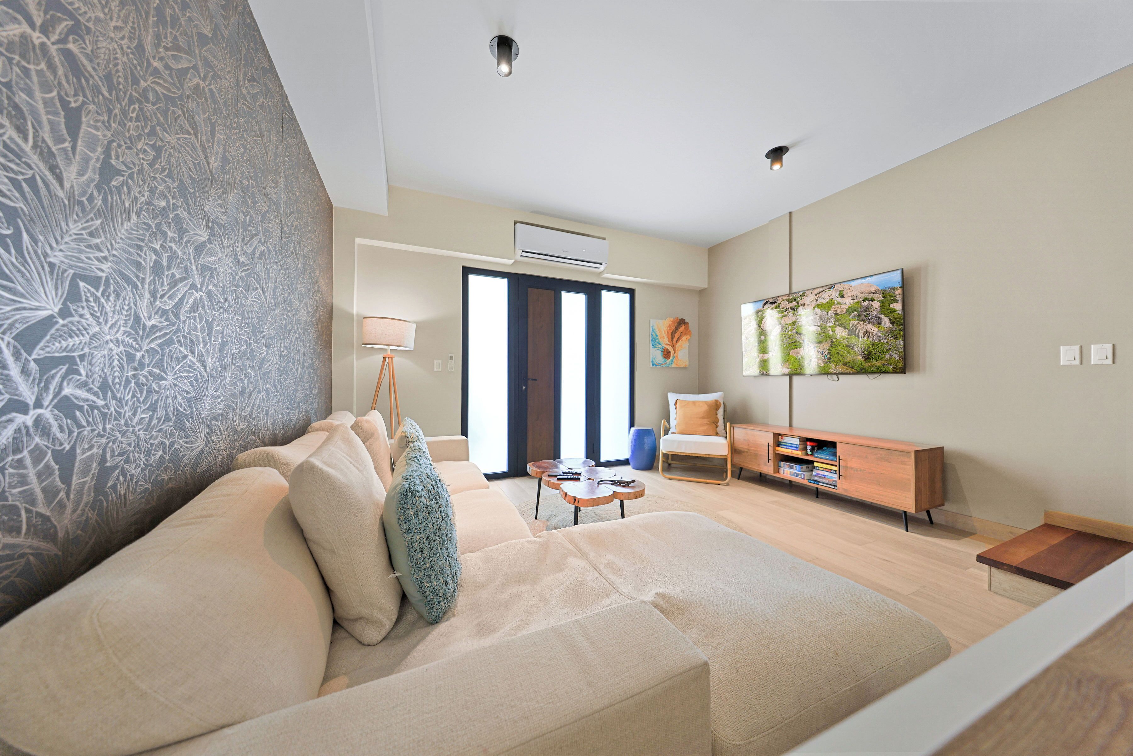 A modern living room with a sofa, a coffee table, a TV, and a bookshelf.