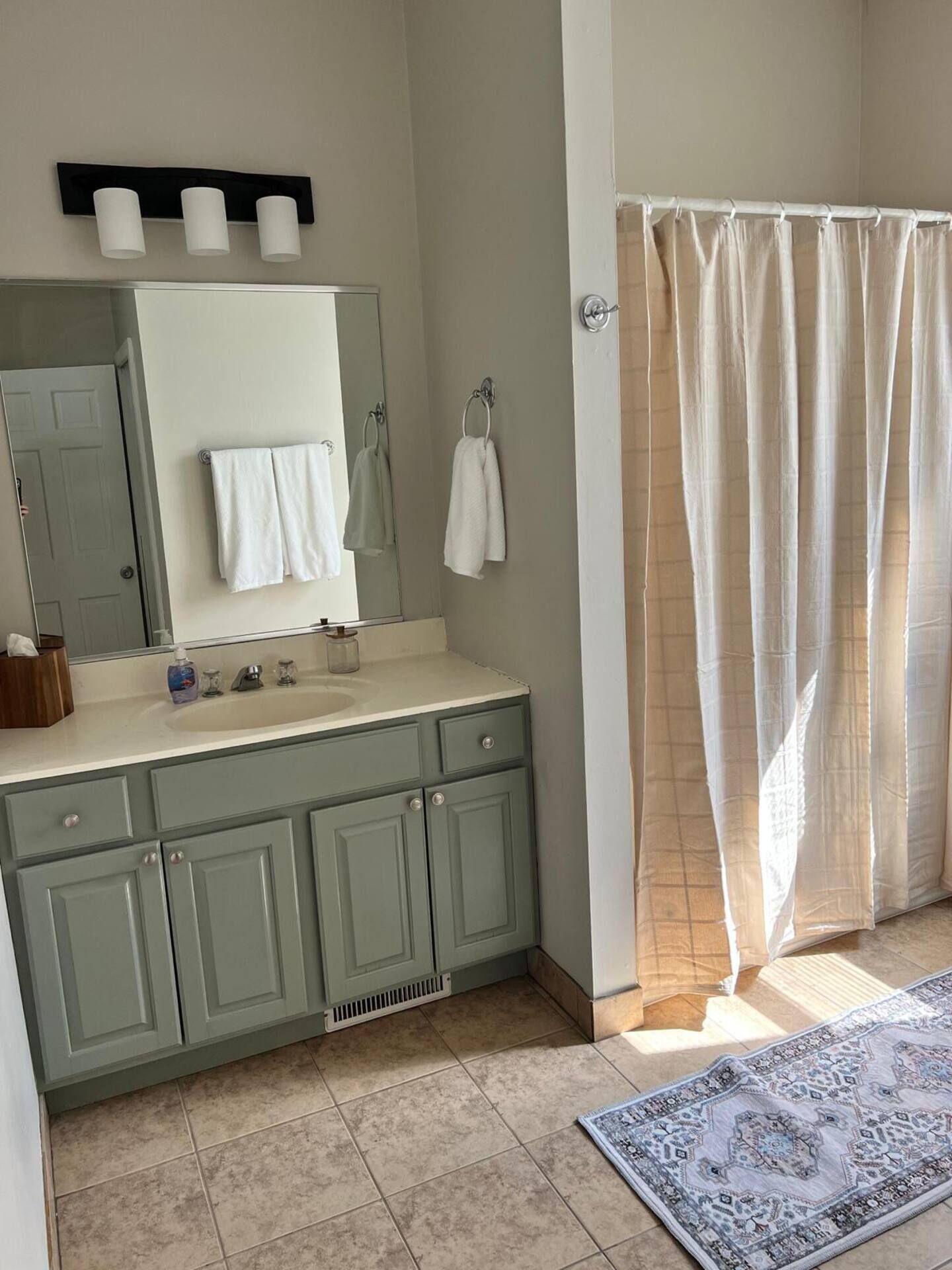A bathroom with a sink, mirror, and towel rack.