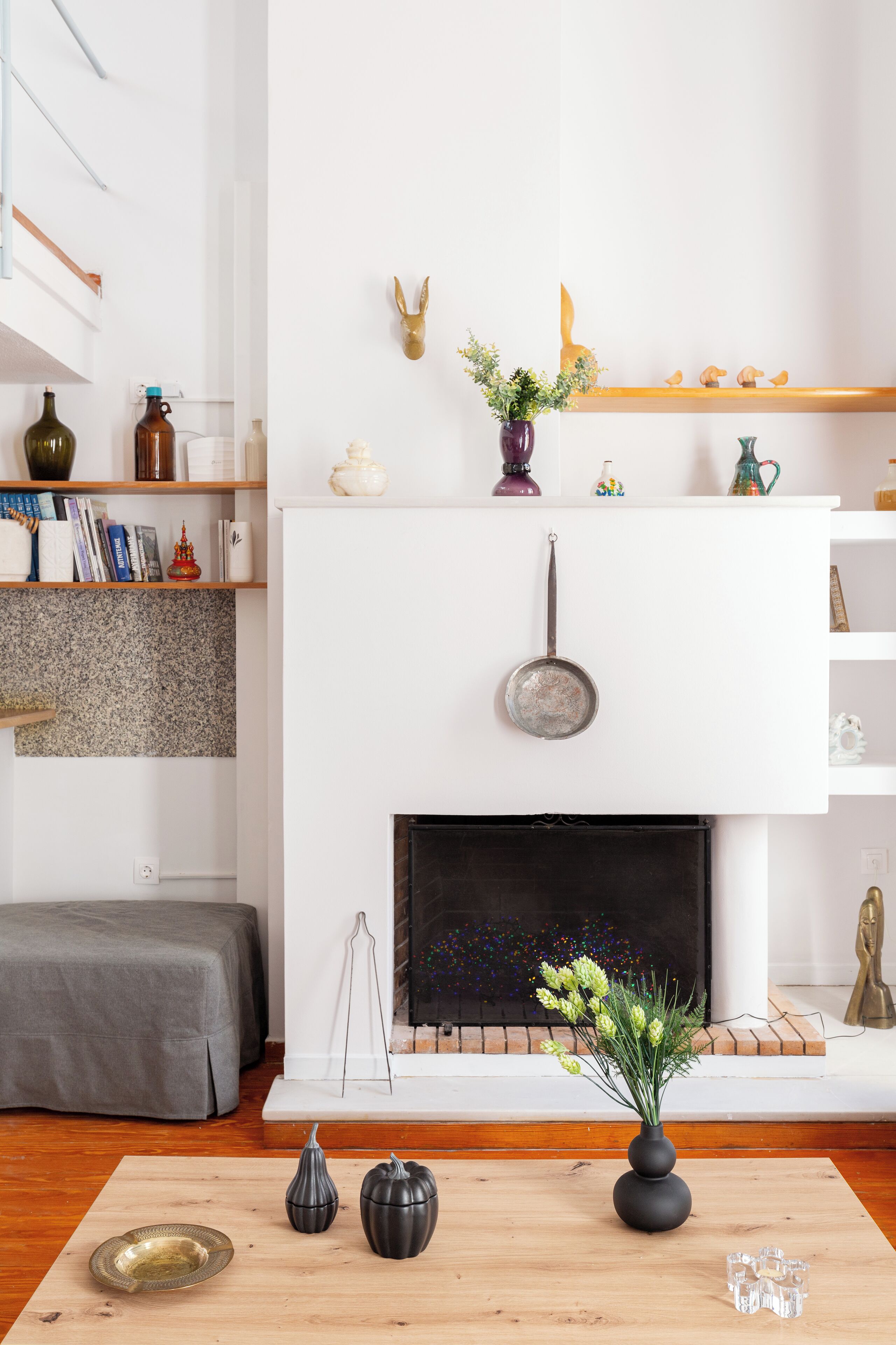 A modern living room with a fireplace, a wooden coffee table, and a bookshelf.