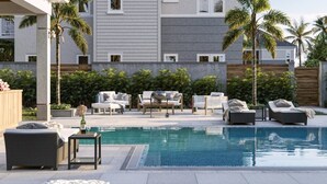 A poolside area with lounge chairs, a small table, and a bottle of champagne.
