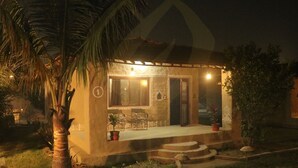 Un petit bâtiment d’un seul étage, doté d’un porche, d’un coin repas et d’une cuisine visible à travers les fenêtres.