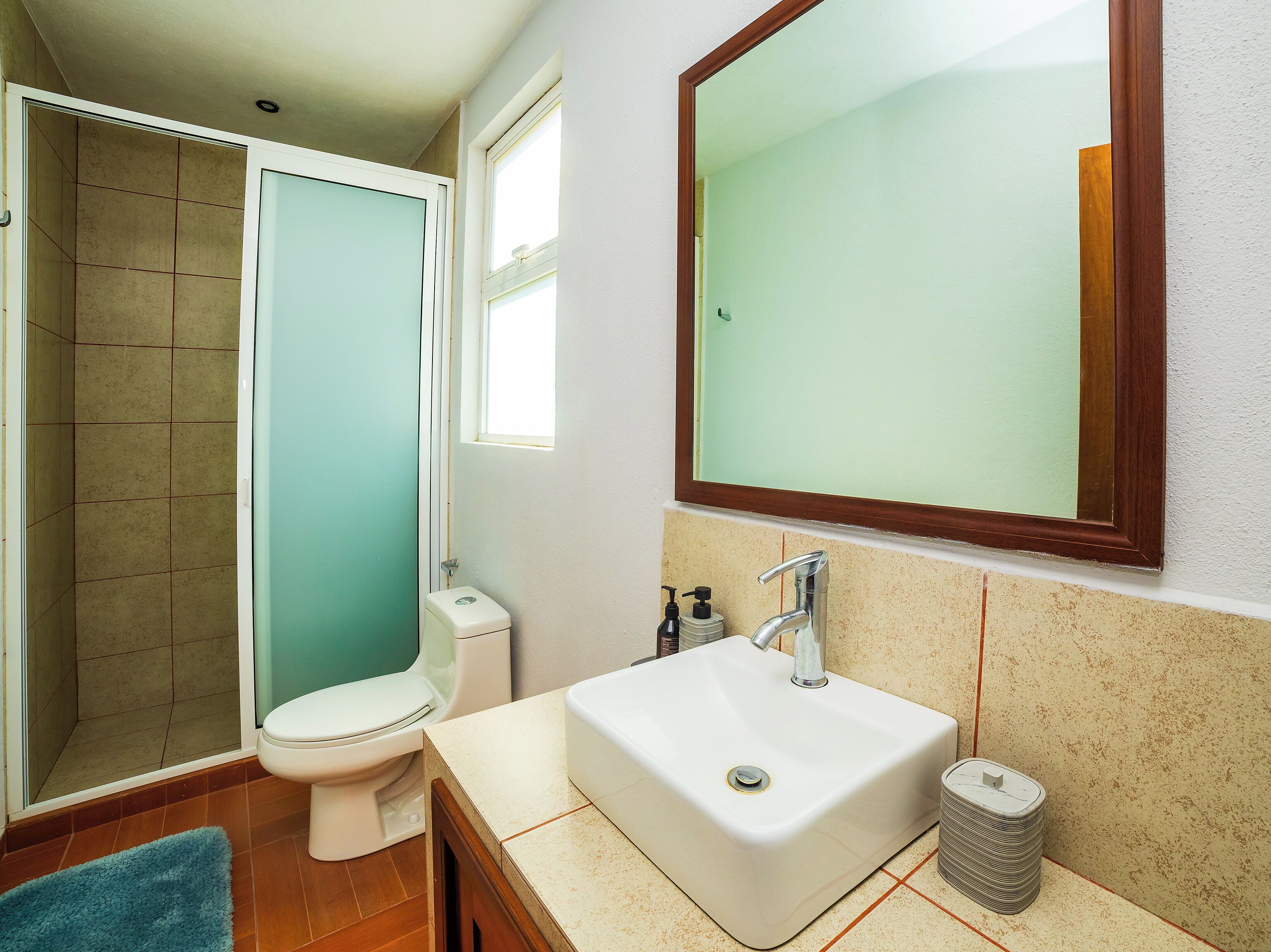 A bathroom with a toilet, sink, and shower.