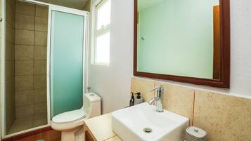 A bathroom with a toilet, sink, and shower.