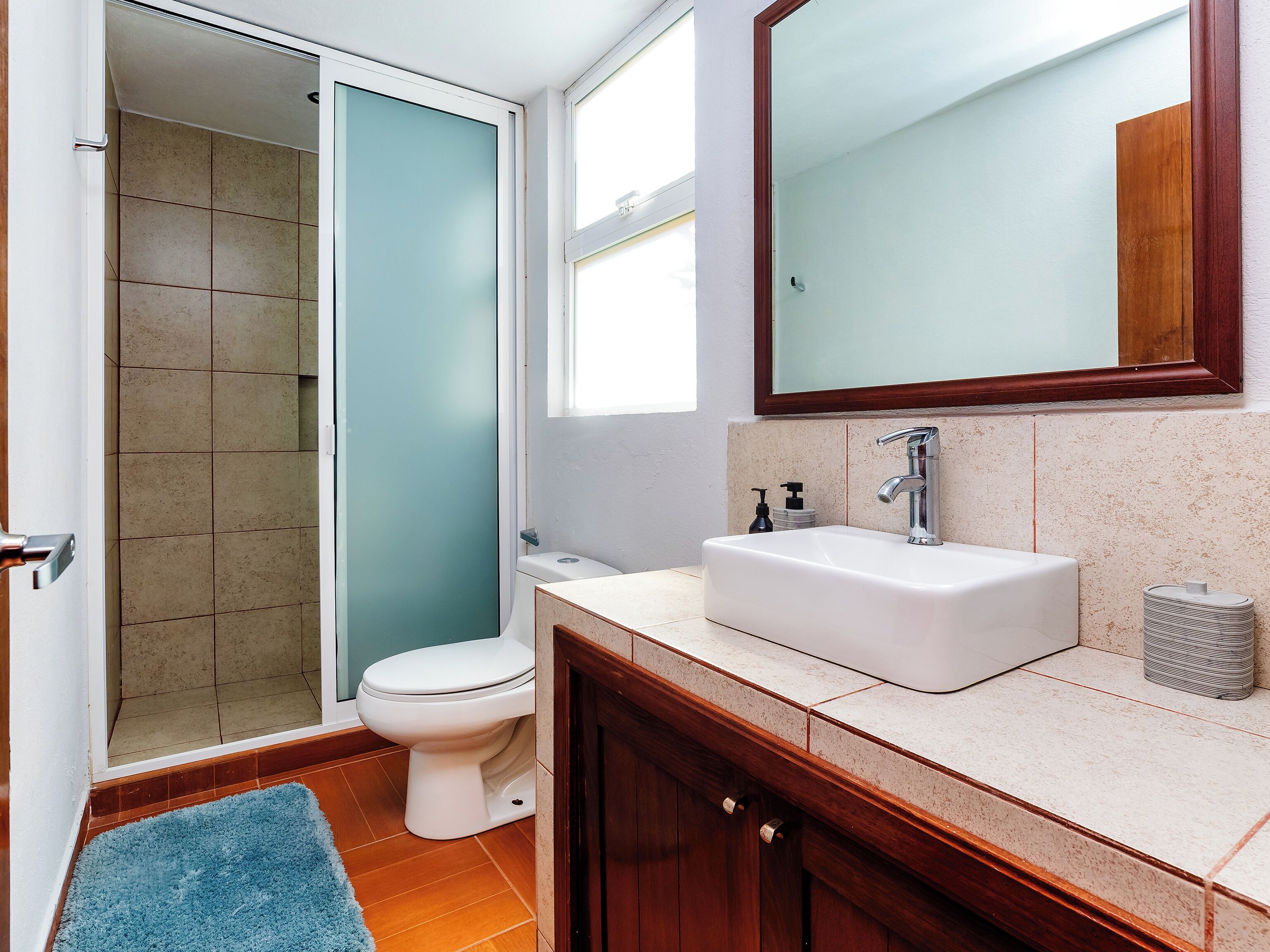 Un baño con inodoro, lavabo y espejo.