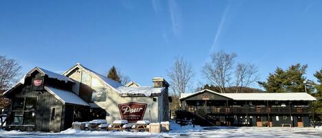 A building with a large sign reading 'Pour Taproom' and another sign 'Lincoln.' Snow covers the ground and buildings.
