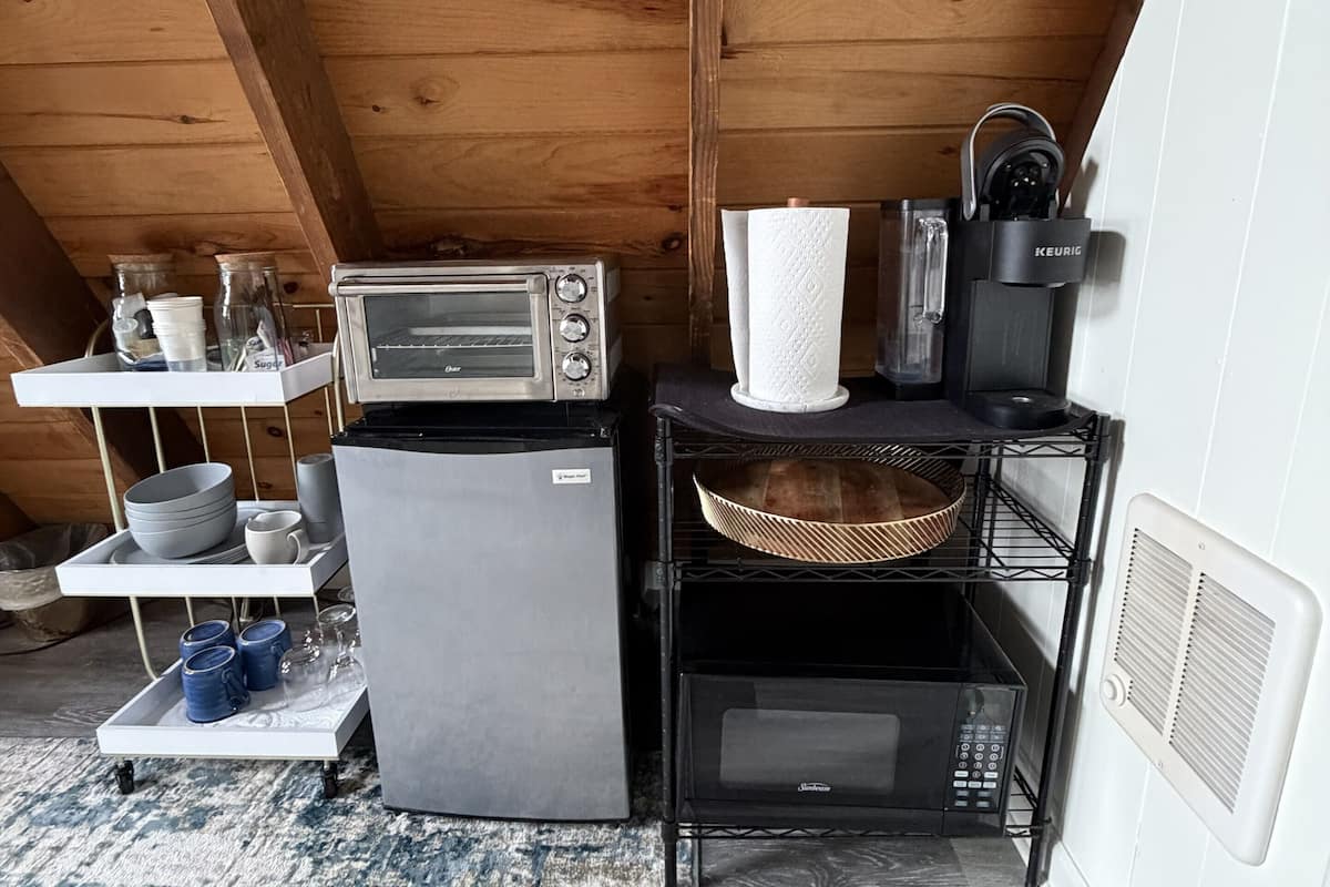 Eine kompakte Küchenzeile mit Toaster, Mikrowelle und Kaffeemaschine.