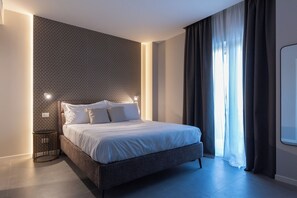 Habitación triple Deluxe, balcón | Artículos del minibar gratis y escritorio 