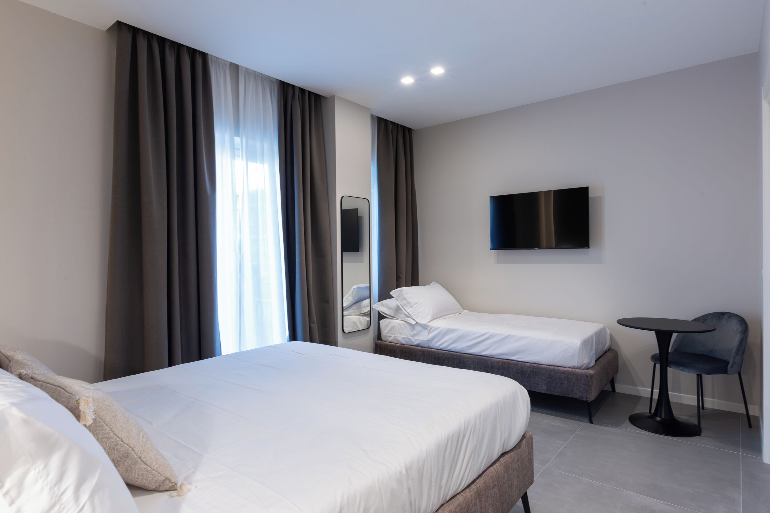 Una habitación de hotel con dos camas, un televisor, una mesita y una silla.