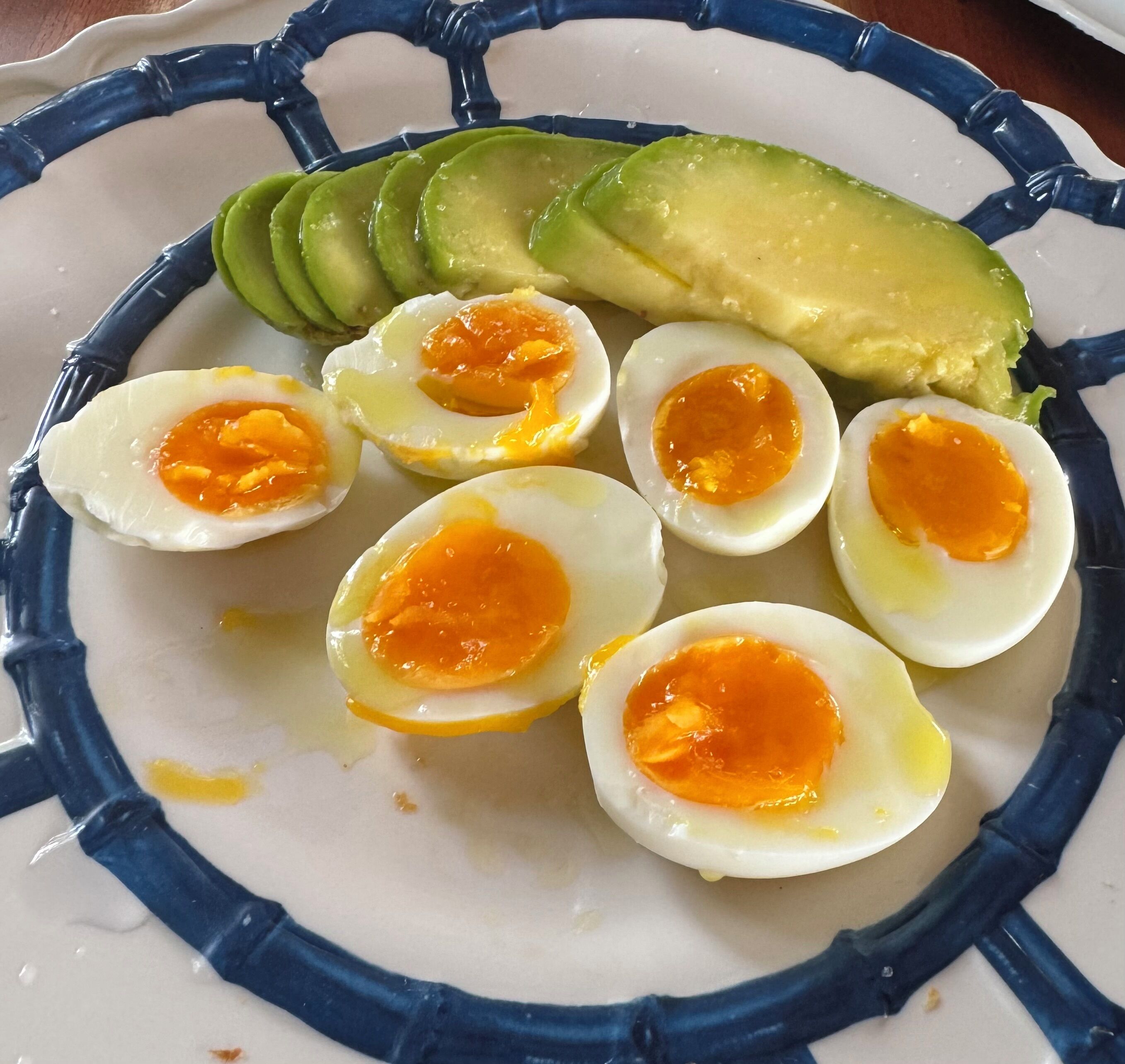 Un piatto con avocado a fette e uova sode tagliate a metà.