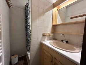 A bathroom with a sink, mirror, and shower curtain. - CYBELE C1 - Apartment in the village center and close to the slopes - Garage (La Clusaz)