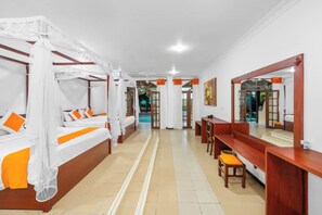 A hotel room with a large bed, a desk, and a view of the pool.