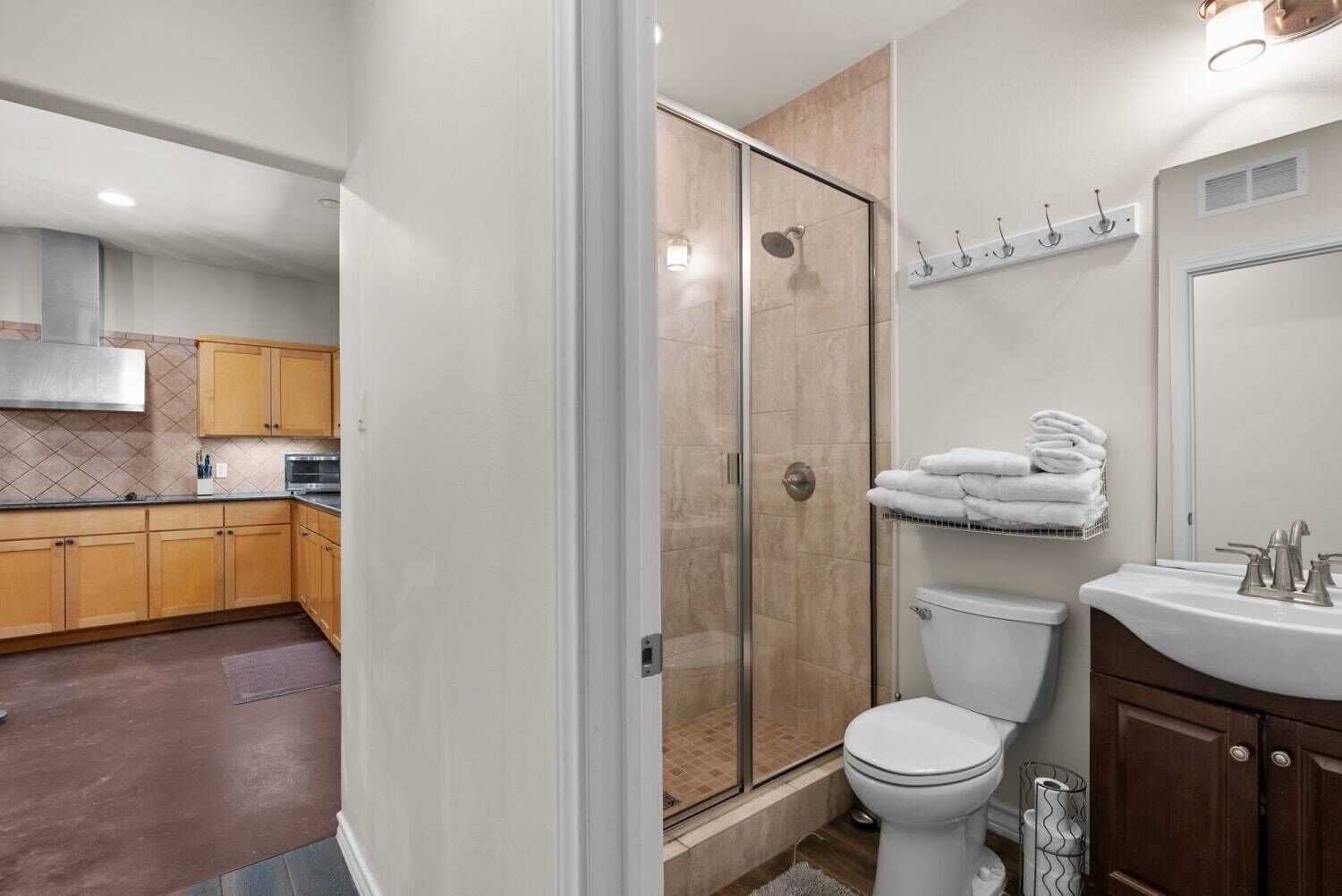 A modern bathroom with a glass-enclosed shower, a toilet, and a sink.
