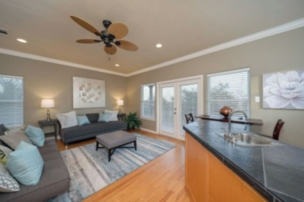 A modern living room with a sofa, coffee table, and a ceiling fan.