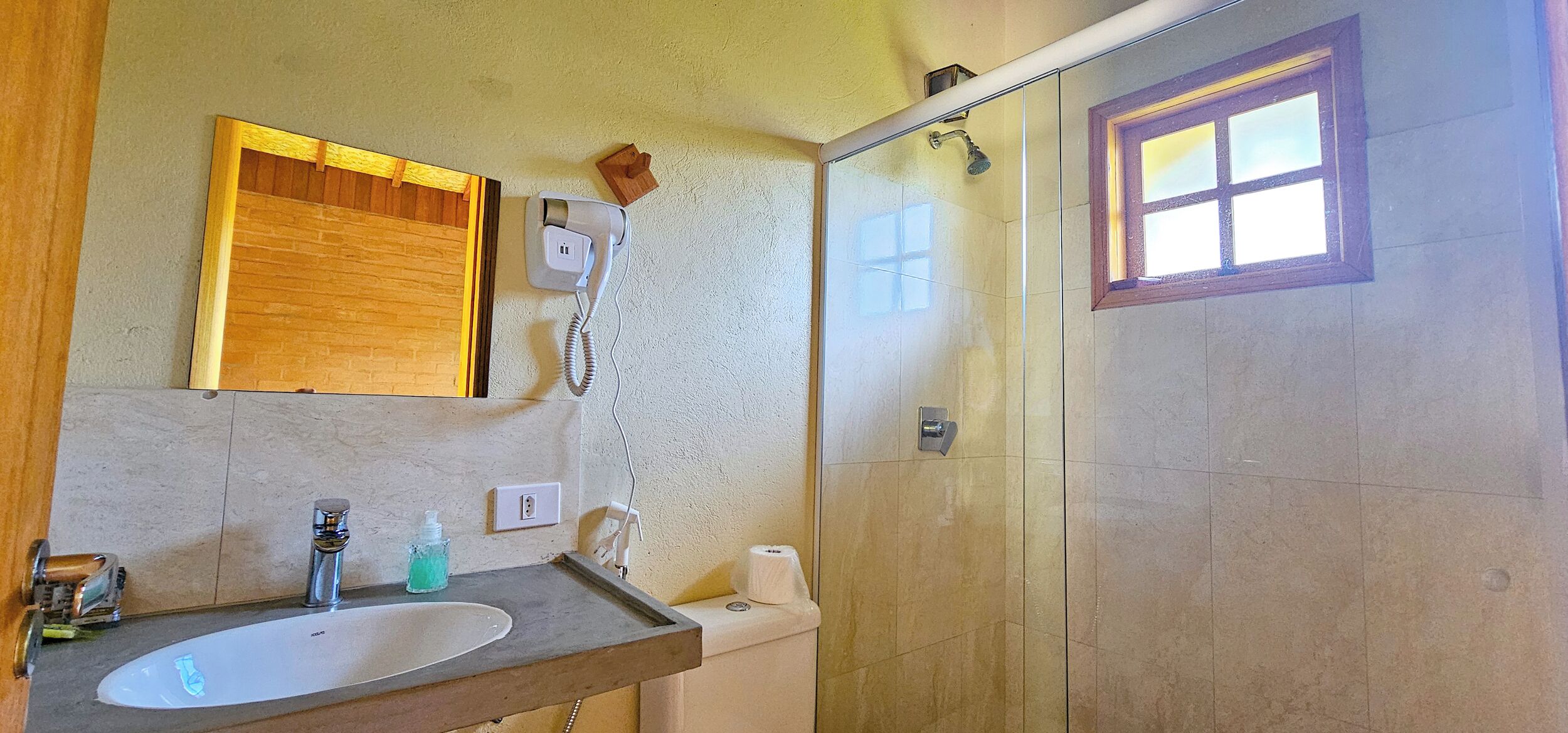 A bathroom with a sink, mirror, and shower.