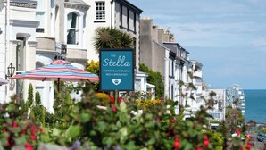 A historic bed and breakfast named "The Stella" with a signboard, located in a coastal town with white buildings and a view of the sea. - The Stella Historic Llandudno B&B (Llandudno)