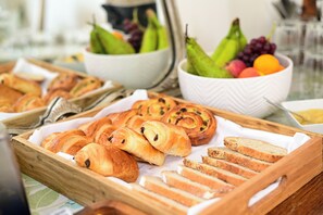 A breakfast buffet with pastries, bread, and a bowl of fruit. - The Stella Historic Llandudno B&B (Llandudno)