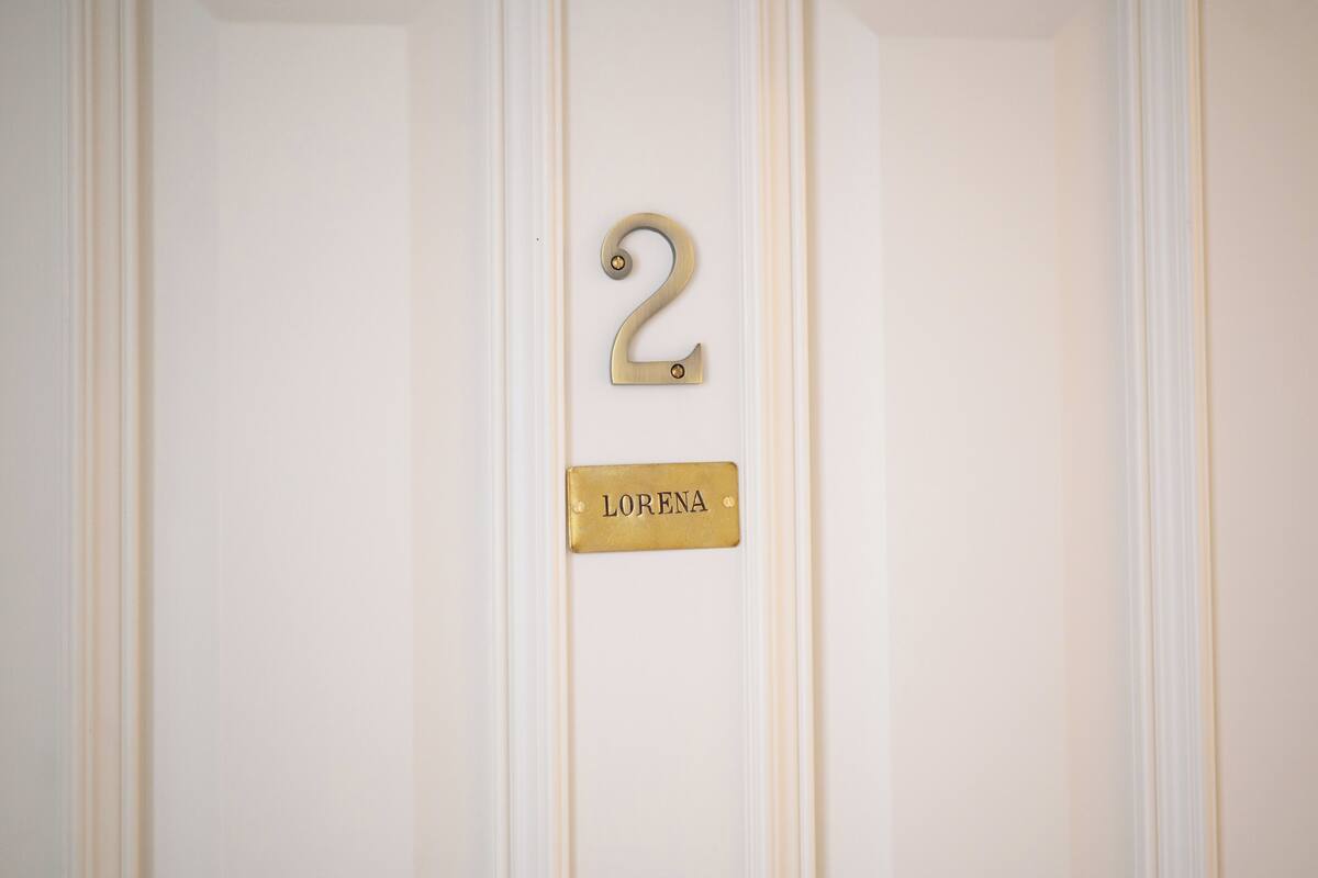 A door with a brass number '2' and a nameplate reading 'LORENA'.