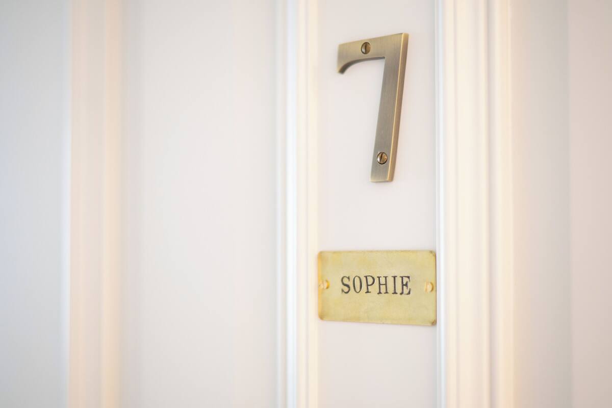 A door with a brass number plate marked '7' and a brass nameplate with the name 'SOPHIE'.