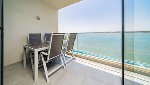 Varanda com duas cadeiras e uma mesa, com vista para um corpo de água.