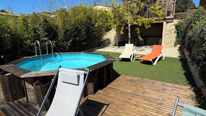 A wooden deck with a hot tub, a pool, and lounge chairs. - Chalet on the hill (Calvisson)