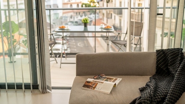 Een moderne woonkamer met een bank, een tijdschrift en een plaid.