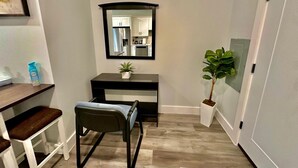 A compact room with a desk, chair, and a mirror. - The Stylish Spot: 1BR with Free Parking (Paterson)