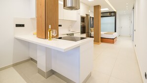 A modern kitchen with a central island, stainless steel appliances, and a wooden accent wall.