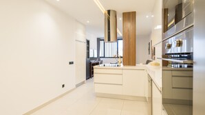 A modern kitchen with white cabinetry, stainless steel appliances, and a central island.