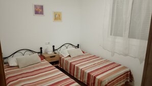 A bedroom with two single beds, a nightstand with a lamp, and two framed pictures on the wall. - Detached Villa with Communal Pool Close to beaches and Golf Course. (Mazarron)