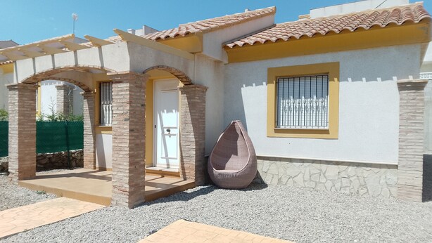 A house with a tiled roof, a stone pillar, and a window with metal bars. - Detached Villa with Communal Pool Close to beaches and Golf Course. (Mazarron)