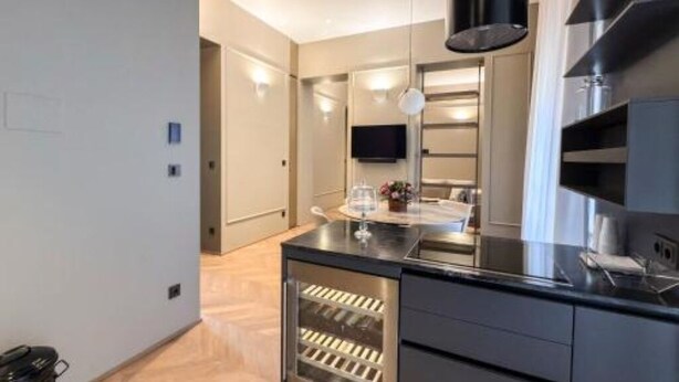 Een moderne keuken met een wijnkoeler, een flatscreen televisie en een ingebouwde oven.
