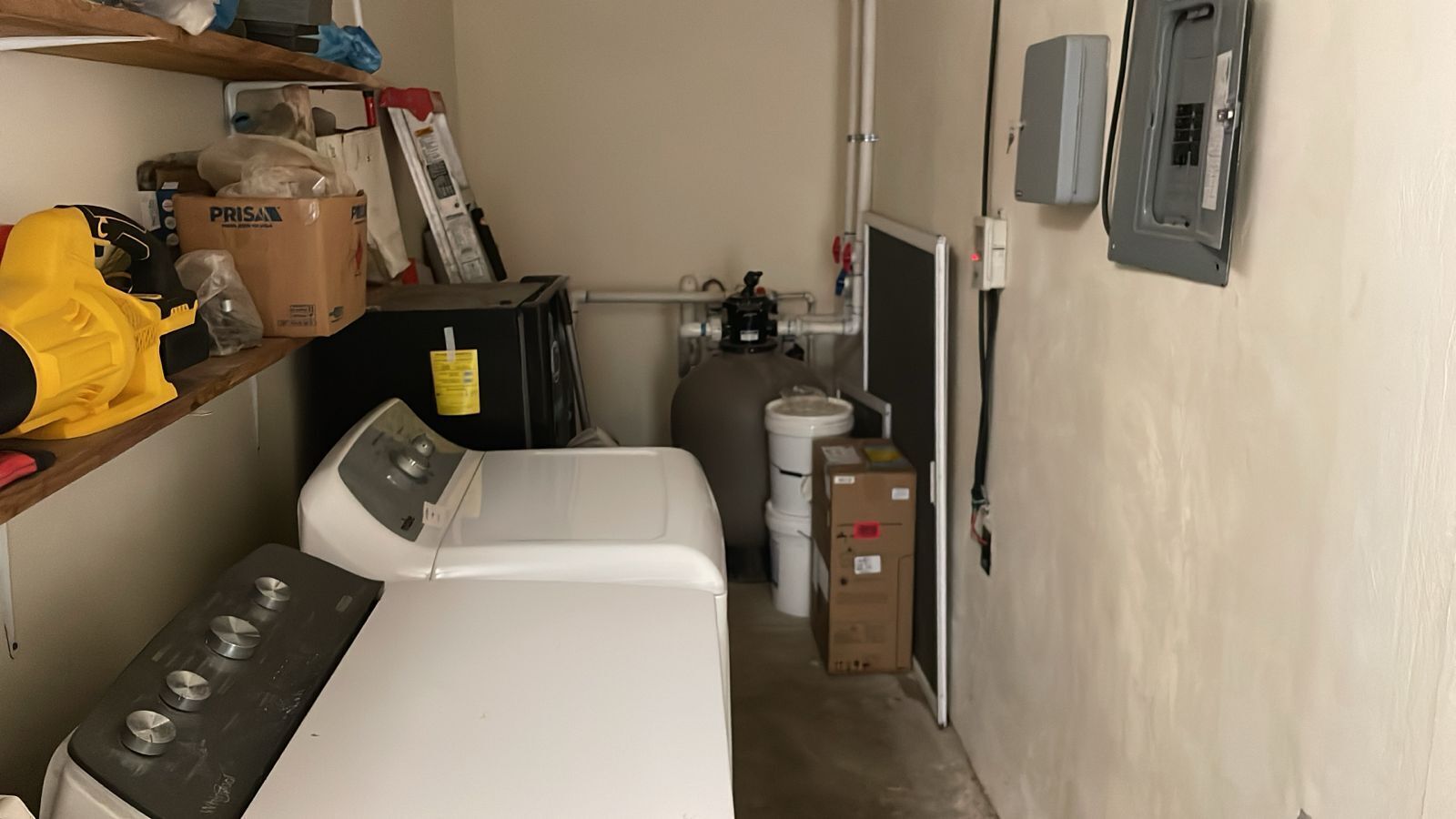 A laundry area with a washing machine, dryer, and stacked boxes.