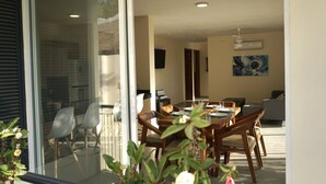 Un comedor con una mesa dispuesta para cuatro personas, rodeada de sillas.