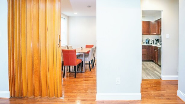 A modern kitchen with wooden cabinets and a dining area with a table and chairs. - Cozy 3 Bedroom/Great Location (Arlington)